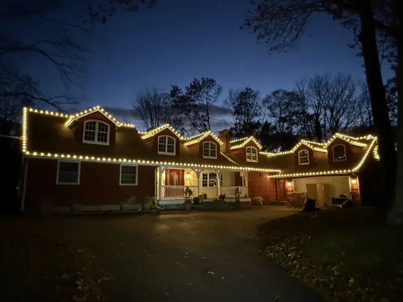 Christmas light installation on Long Island by North Star: warm white roofline tracing every dormer