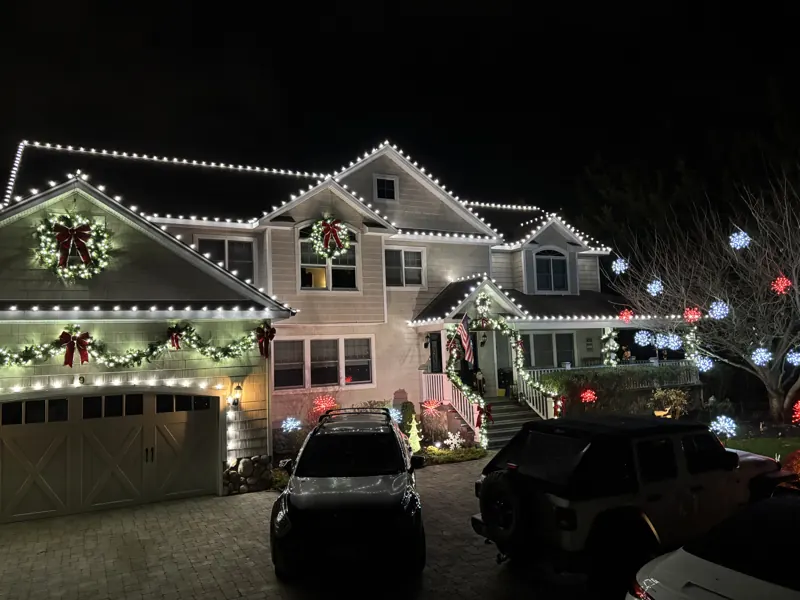 Christmas light installation on Long Island by North Star: warm white roofline with wreaths and garland