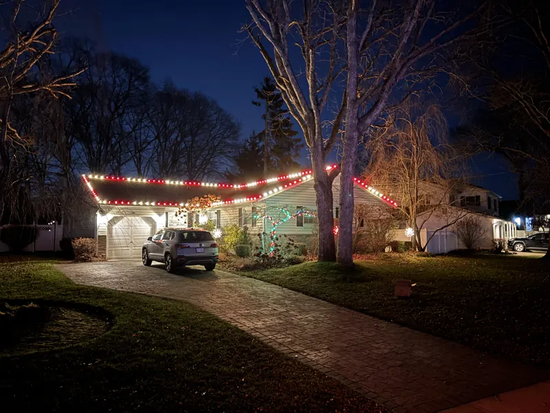 Christmas light installation on Long Island by North Star: red and white roofline with lit trees