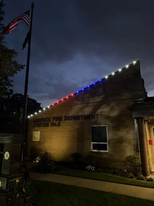 Permanent outdoor lighting on Long Island by North Star: firehouse roofline in red, white and blue